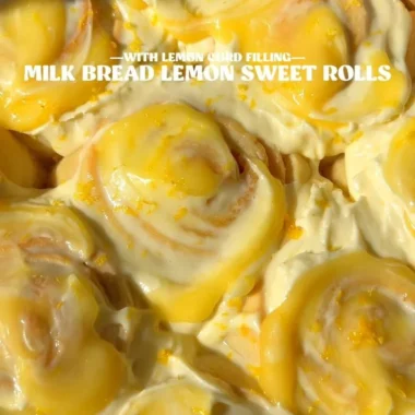 Homemade lemon rolls with a glaze on a wooden table