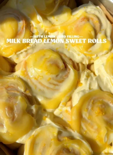 Homemade lemon rolls with a glaze on a wooden table