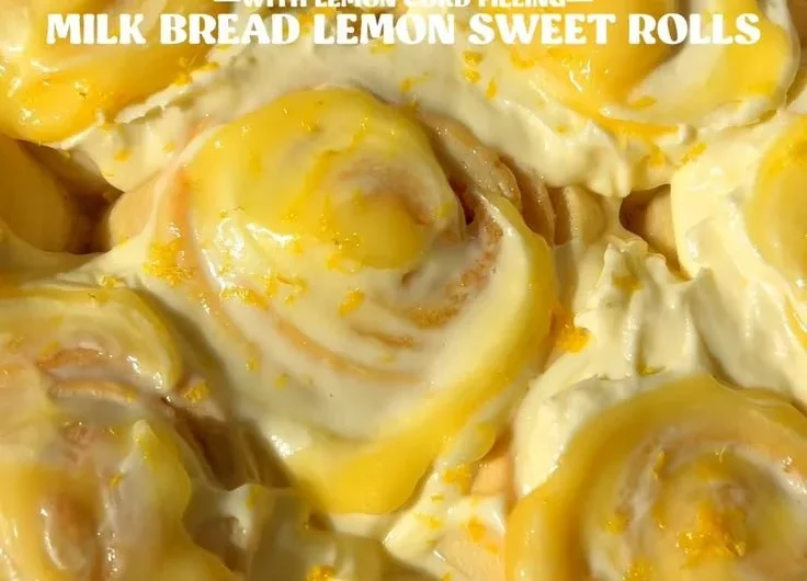 Homemade lemon rolls with a glaze on a wooden table