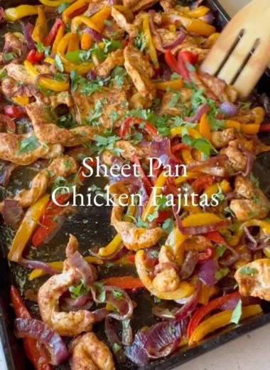 Sheet pan chicken fajitas with colorful peppers in a flavorful seasoning blend.