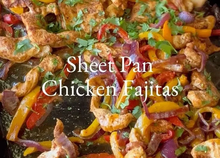 Sheet pan chicken fajitas with colorful peppers in a flavorful seasoning blend.