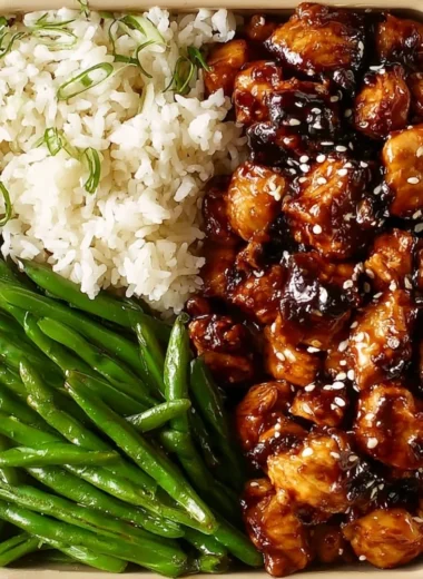 Plate of Asian high protein sesame chicken garnished with sesame seeds and vegetables
