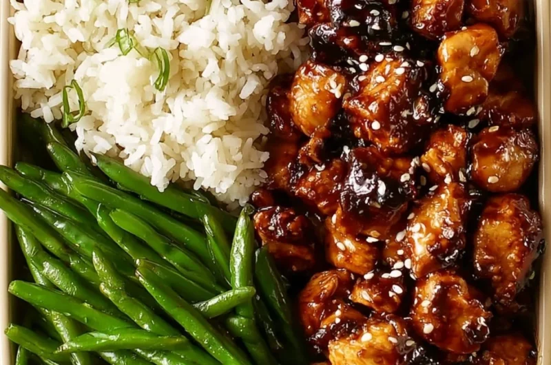 Plate of Asian high protein sesame chicken garnished with sesame seeds and vegetables