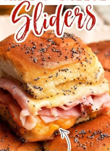 Baked ham and cheese sliders fresh out of the oven, melted cheese and golden crust.