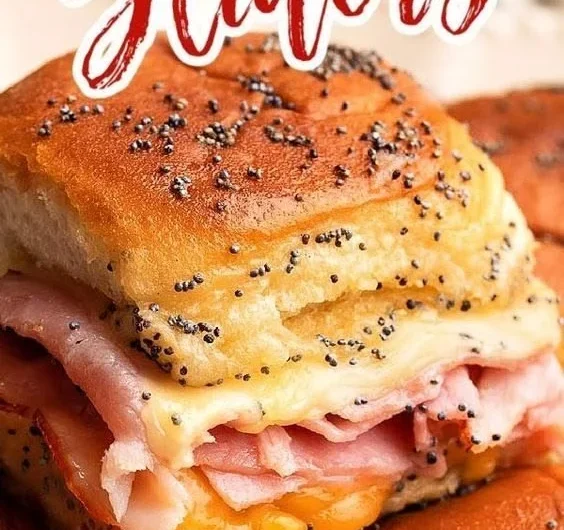Baked ham and cheese sliders fresh out of the oven, melted cheese and golden crust.