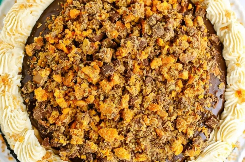 Delicious Butterfinger Cheesecake topped with crushed Butterfinger candy.