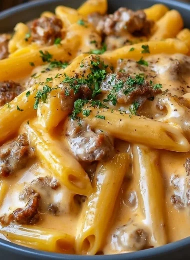 Creamy beef pasta dish served in a bowl with fresh herbs and garnishes