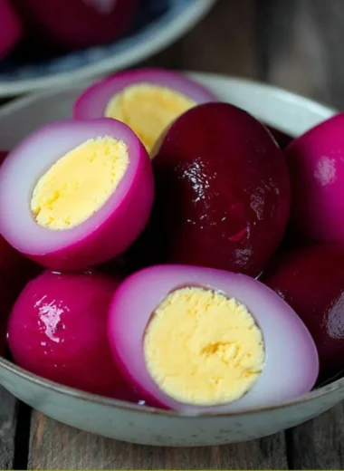 A jar of vibrant and appetizing easy pickled eggs sitting on a kitchen counter.