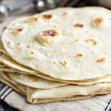 Freshly made homemade flour tortillas on a wooden surface