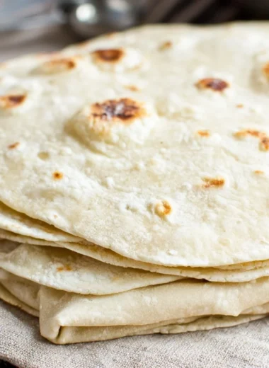 Freshly made homemade flour tortillas on a wooden surface