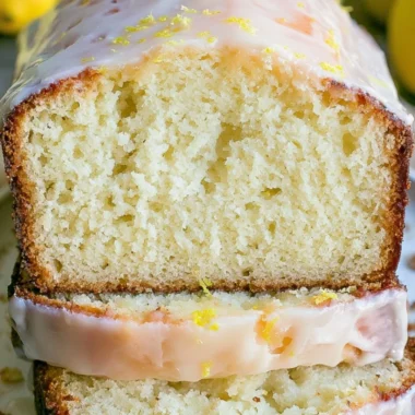 Moist lemon pound cake with a zesty lemon glaze on a white plate.