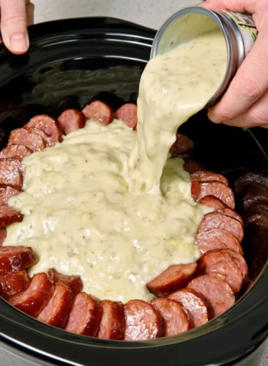 Amish-style sausage noodle bake cooked in a slow cooker, garnished and ready to serve.