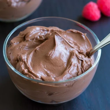 Delicious vegan chocolate pudding in a dessert bowl topped with cocoa powder.