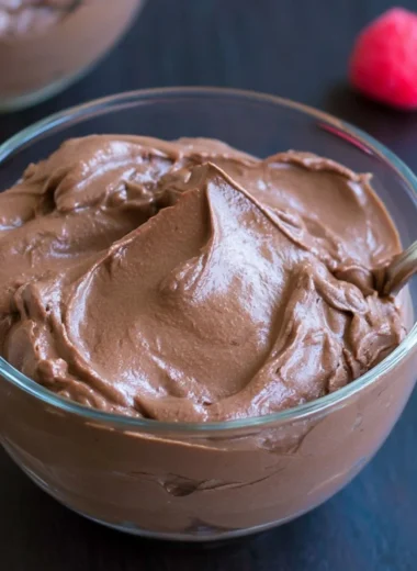 Delicious vegan chocolate pudding in a dessert bowl topped with cocoa powder.