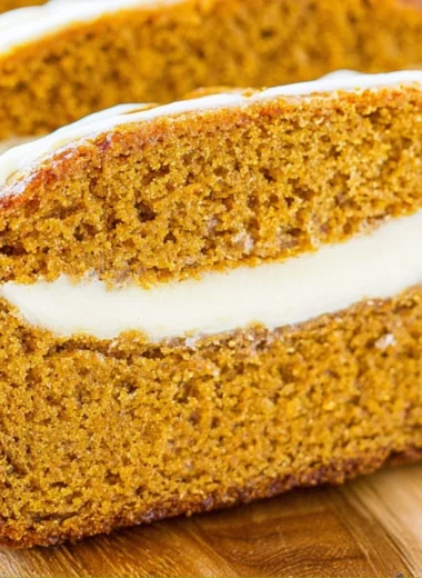 Cozy pumpkin bread with cream cheese frosting on a wooden table
