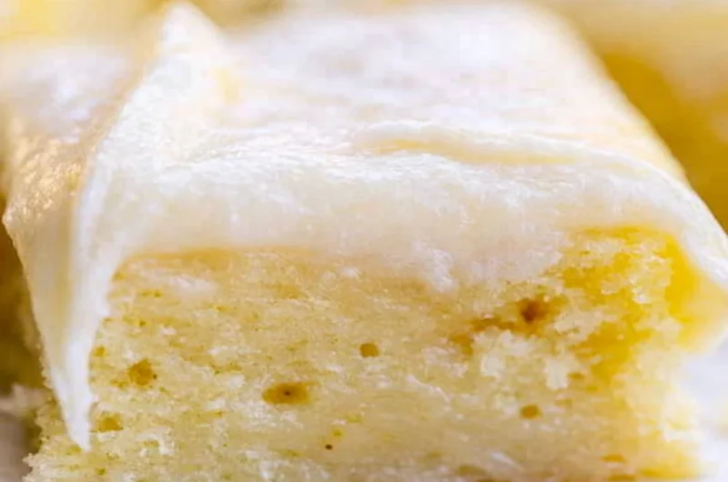 Cozy White Texas Sheet Cake served on a plate with a slice cut out