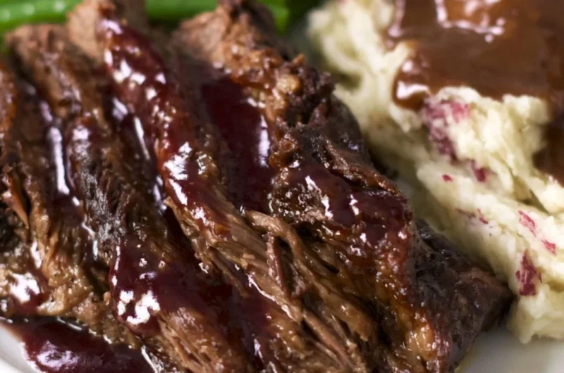 Delicious Crock Pot Chuck Roast served with vegetables and herbs