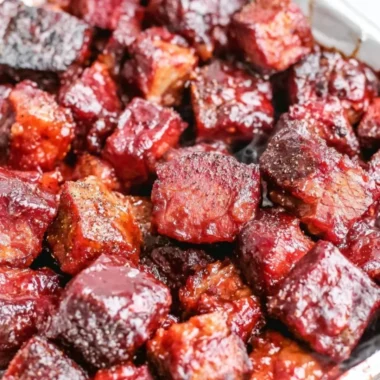 Delicious Poor Man's Burnt Ends served on a plate with BBQ sauce.