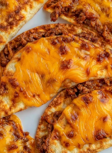 Sheet pan tacos ready to serve, topped with fresh ingredients and cheese.