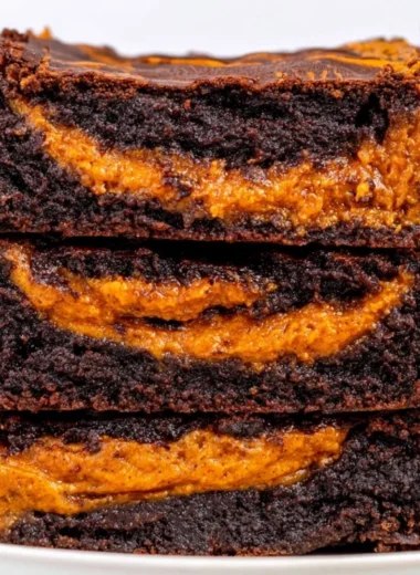 Deliciously baked cozy pumpkin brownies topped with chocolate drizzle.