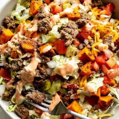 Sweet Potato Burger Bowl topped with fresh vegetables and sauce